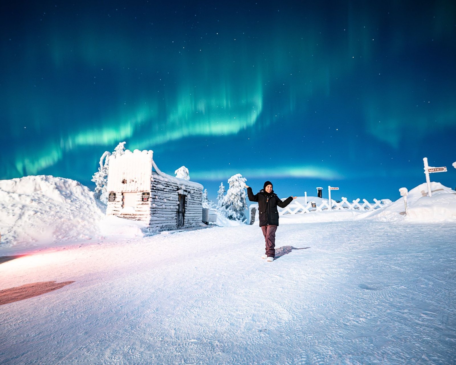 Happy guest under the northern lights on a fell top in Lapland