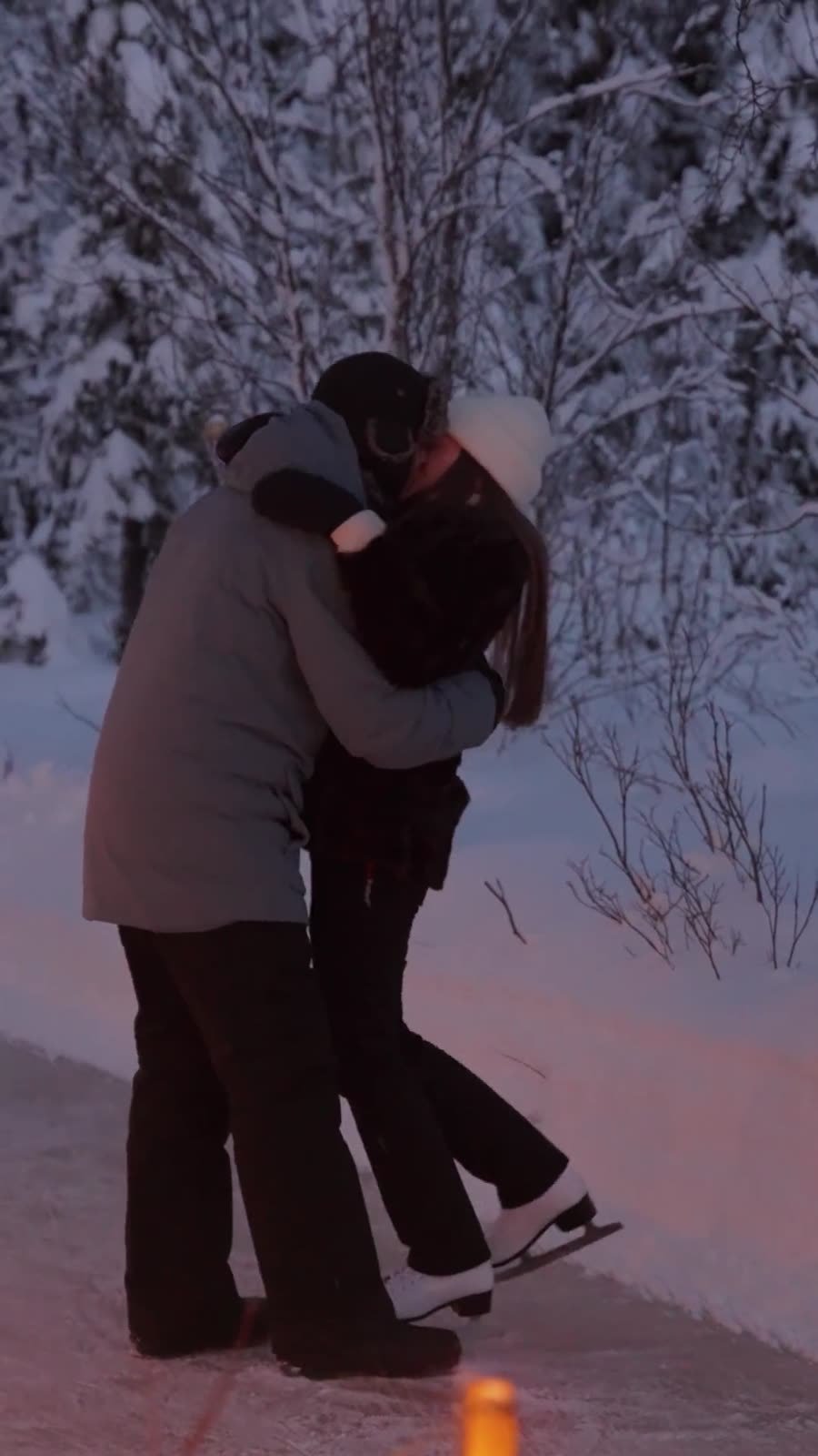 Couple ice skating on a lantern-lit rink in Lapland
